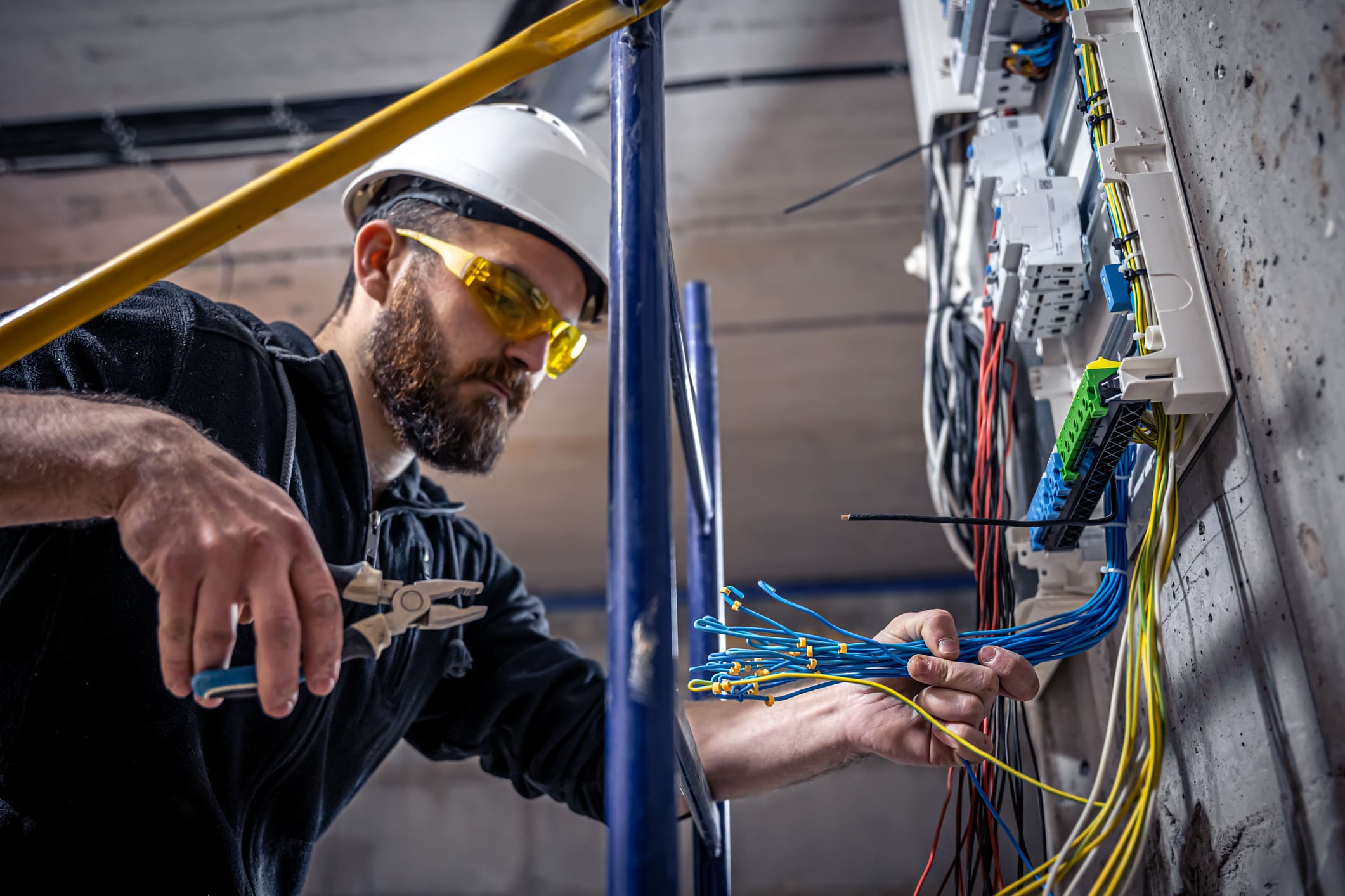 Electrician working on a circuit breaker panel.