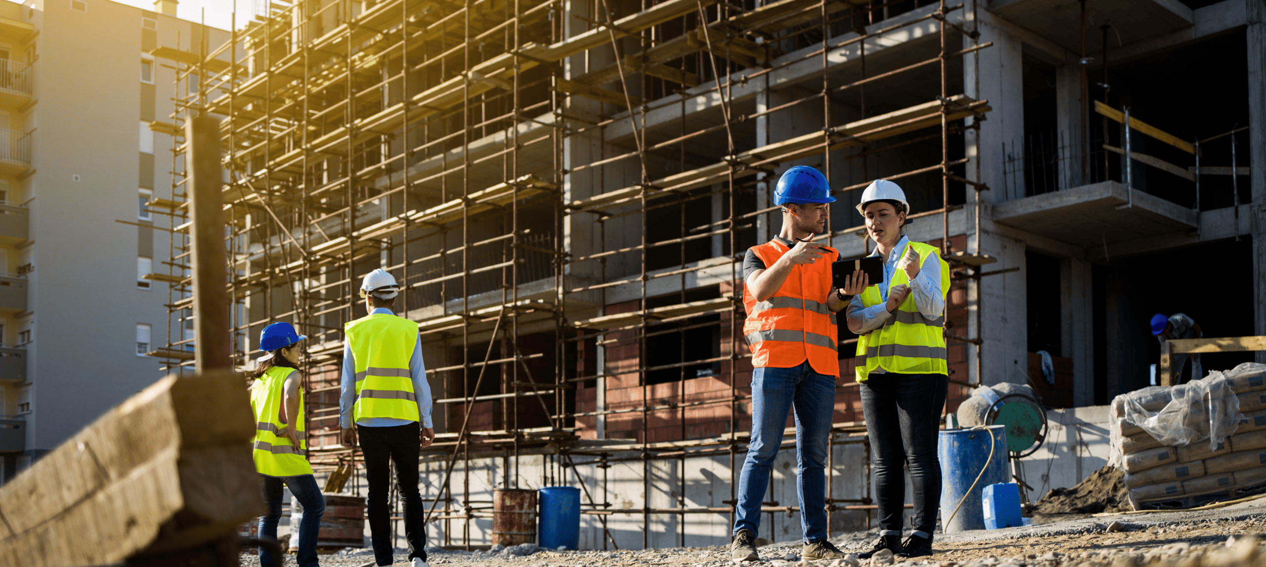 Construction workers discussing at building site.