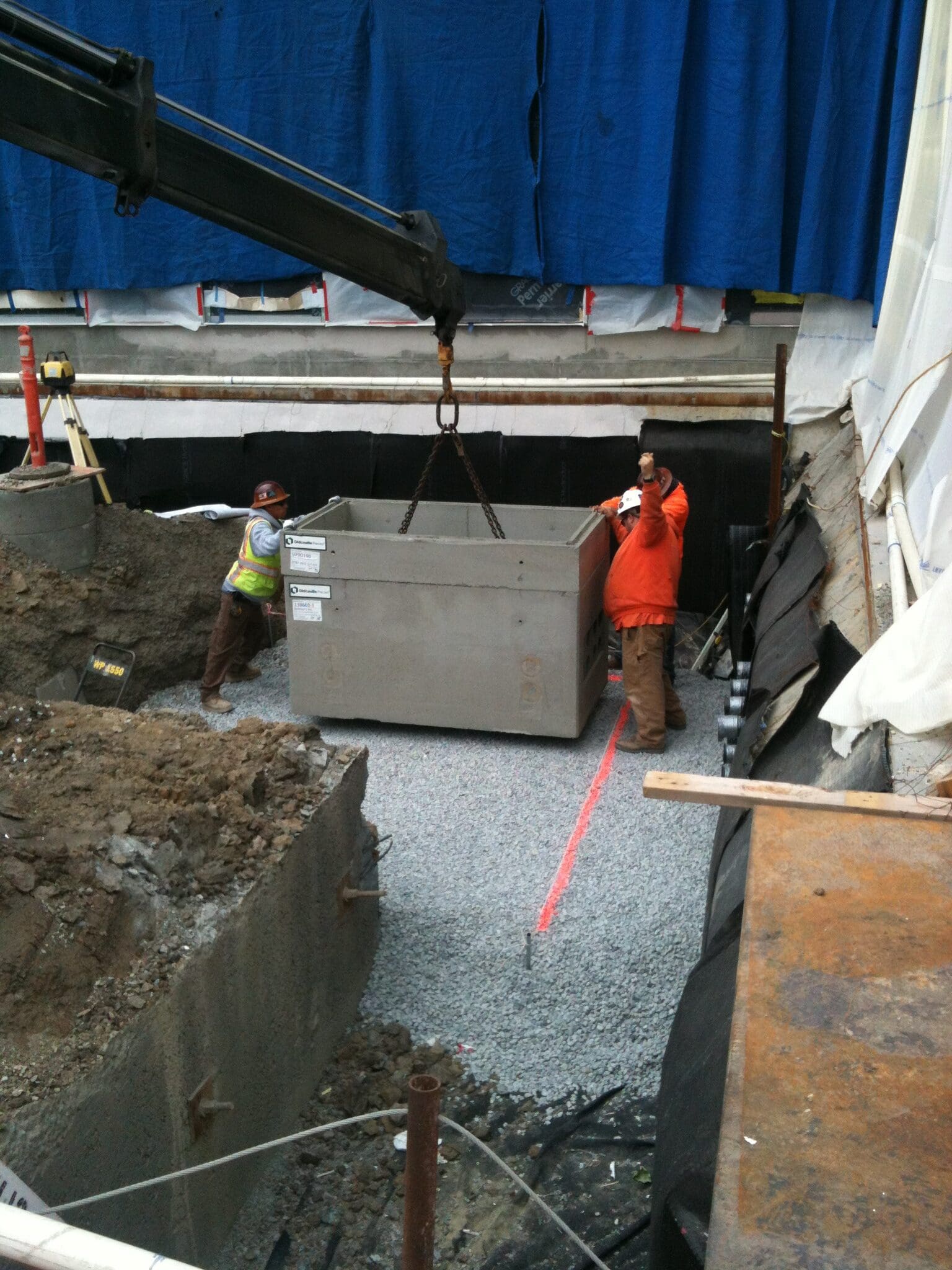 Crane lowering concrete container at site