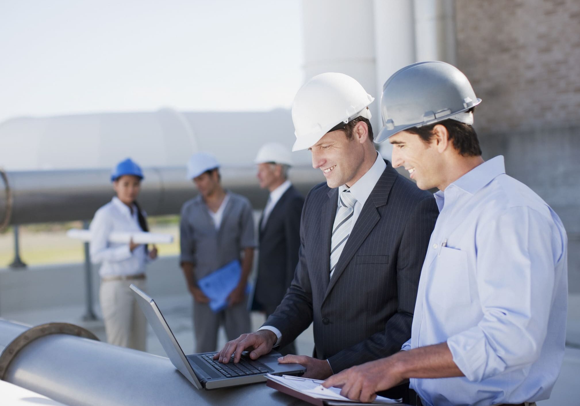 Engineers discussing plans at construction site.