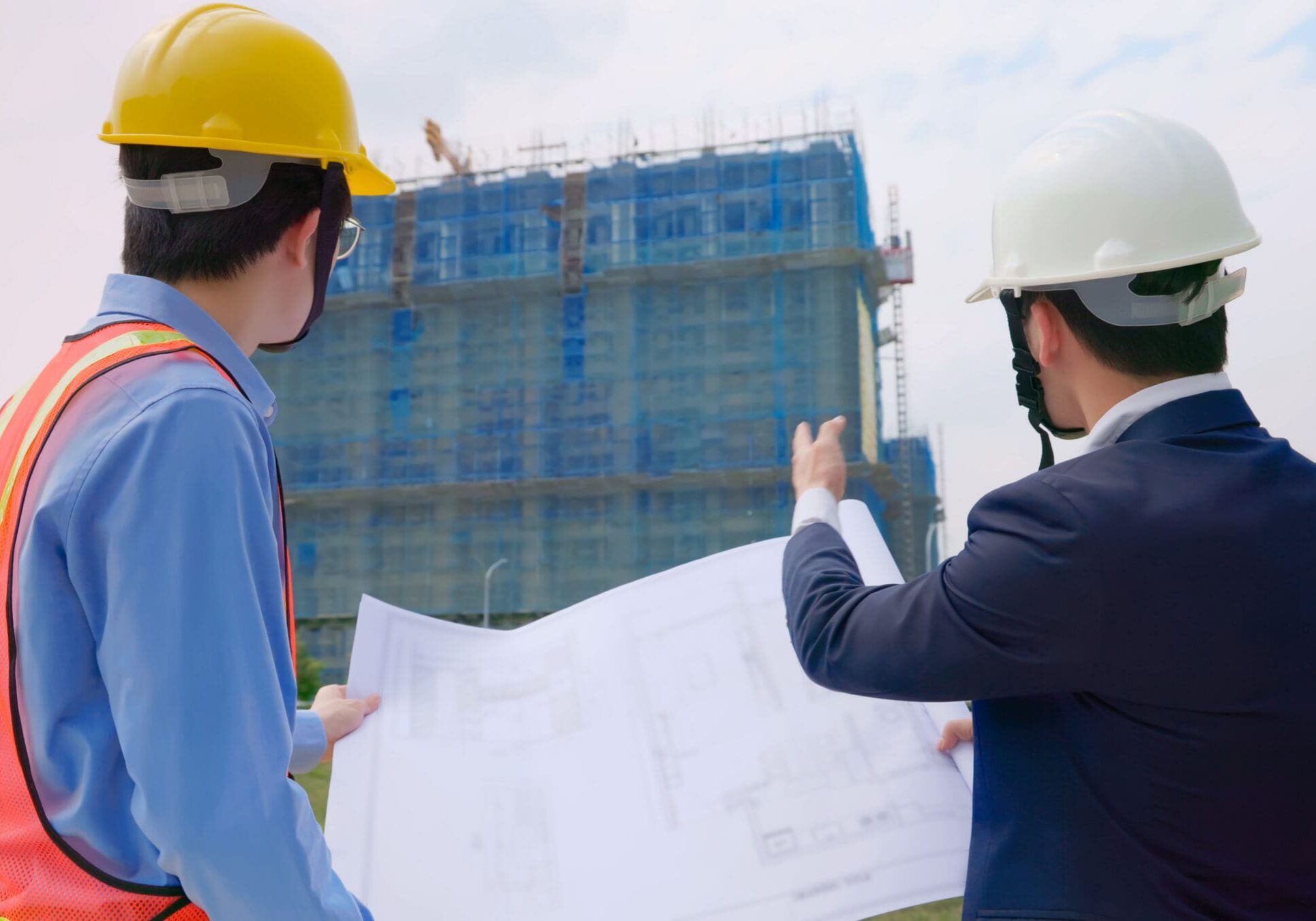 Two engineers reviewing construction site plans.